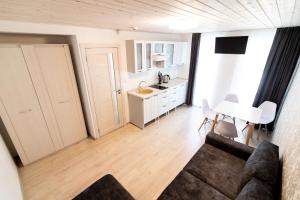 a living room with a couch and a kitchen at Floros simfonija vilos in Šventoji