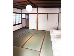 ein leeres Zimmer mit weißen Schränken und einem Bett in der Unterkunft KINOSAKI KNOT - Vacation STAY 83611 in Toyooka