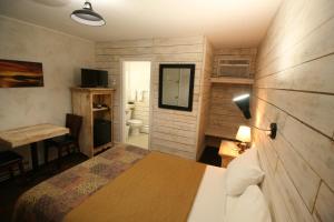 a bedroom with a bed and a desk and a bathroom at Motel du Bic in Bic