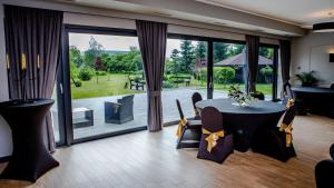 a living room with a table and chairs and a large window at Ranczo Daniela in Pobiedziska