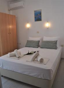 a large white bed with towels on it at Sea La Vie - Studios Maria in Limenaria