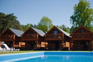 um grande chalé de madeira com uma piscina em Wrzosowa Polana - domki letniskowe em Mrzeżyno