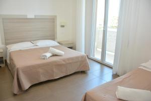 a hotel room with two beds and a balcony at Hotel Marisa in Riccione