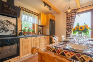 a kitchen with a dining table and a dining room at Villa Kierpcóweczka in Kościelisko