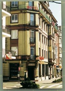 un grand bâtiment sur une rue de la ville avec un panneau d'arrêt dans l'établissement Amadeus Hotel, à Sarreguemines