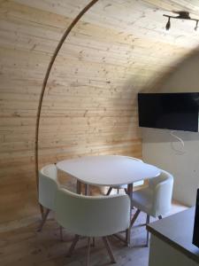 a dining room with a white table and chairs at les insolites du villaret in Saint-Vincent-les-Forts