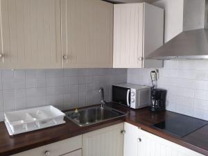 a kitchen with a sink and a microwave at PEQUEÑA CASA CERCA DE MIKONOS CIUDAD in Mikonos