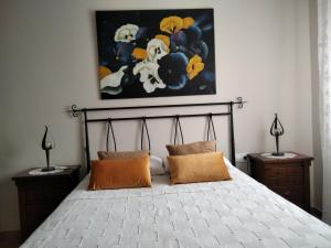 a bedroom with a bed with a painting on the wall at Casa Lahuerta 2 in Bronchales