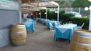 a group of tables and chairs with blue tables and barrels at Mondello Addaura Home Holiday in Mondello