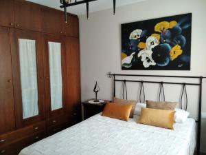 a bedroom with a bed with a painting on the wall at Casa Lahuerta 2 in Bronchales +8 photos