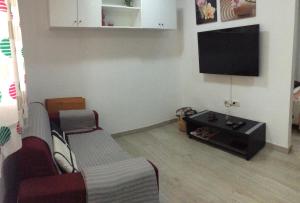 sala de estar con sofá y TV de pantalla plana en Estudio La Esperanza, en La Esperanza
