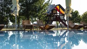 
a pool with a lawn chair and a pool table at Hotel and Park Divoká Voda in Bratislava
