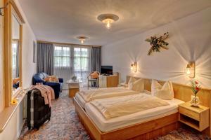 ein Schlafzimmer mit einem großen Bett und ein Wohnzimmer in der Unterkunft Ferienhotel Kollmerhof in Rimbach
