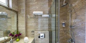 a bathroom with a shower with a glass door at Hotel Odysseas in Polychrono