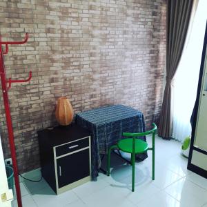 a table and a chair next to a brick wall at Ida´s House- Holiday Home in Midang