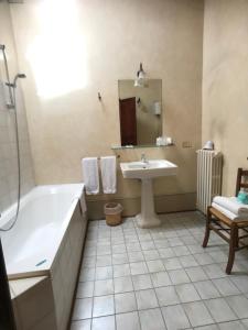 y baño con bañera y lavamanos. en camere della vecchia posta, en Trevi