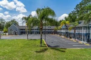 ein großes Gebäude mit einer Palme davor in der Unterkunft GatorTown Inn in Gainesville