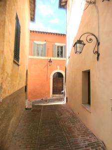 un callejón en un viejo pueblo con un edificio en camere della vecchia posta, en Trevi