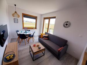 a living room with a couch and a table at BALT Marynarska 8 in Sarbinowo