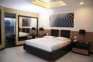 sypialnia z łóżkiem i dużym lustrem w obiekcie Motel Hollywood w mieście Salvador