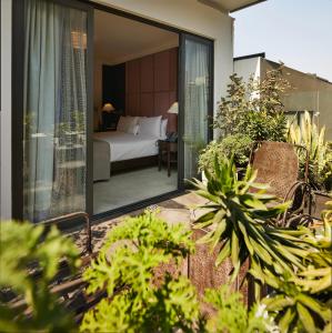 a hotel room with a bed and a balcony with plants at Hippodrome Hotel Condesa in Mexico City
