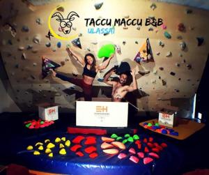 two people standing in front of a rock wall with a cake at B&B Taccu Maccu in Ulassai