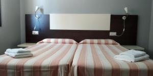 a bedroom with a bed with towels on it at Apartaments La Farga Arbúcies in Arbúcies