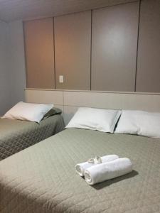 two beds with towels sitting on top of them at Hotel Morada dos Pinheiros in Bom Jardim da Serra +26 photos