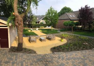 eine Terrasse mit Stühlen um einen Baum im Hof in der Unterkunft B&B Reveille in Kleve