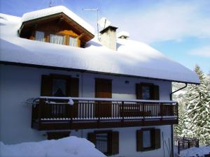 Casa cubierta de nieve con balcón en Casa Pergher, en Folgaria