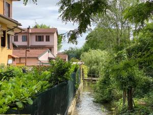H & B Corte Ponti في Vermezzo: نهر امام منزل بجانب منزل