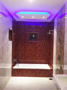 Grand Villa Negombo في نيجومبو: حمام مع حوض استحمام مع أضواء أرجوانية