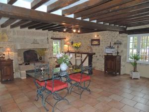 a living room with a table and chairs and a fireplace at 7 , le Haut Montrayé in Pacé