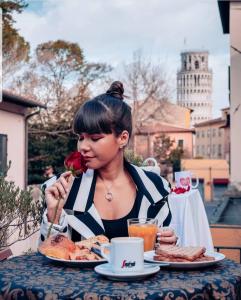 uma mulher sentada numa mesa com um prato de comida em Hotel Francesco em Pisa