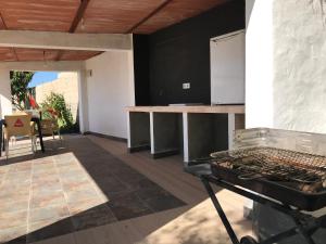 una cocina al aire libre con parrilla y mesa en Chalet en Conil, descansa y disfruta, en Conil de la Frontera