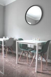 a dining room with a table and chairs and a mirror at Genius Loci Guesthouse in Matosinhos