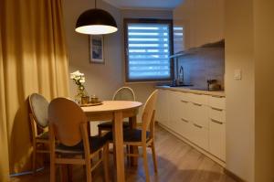 kuchnia ze stołem i krzesłami w pokoju w obiekcie Apartamenty Park w mieście Mielno