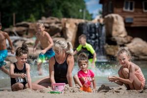 un grupo de niños jugando en la arena en la playa en Natura Treescape Resort en Wisconsin Dells