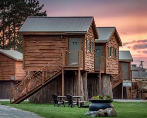 a tree house with a deck on a tree stump at Natura Treescape Resort in Wisconsin Dells