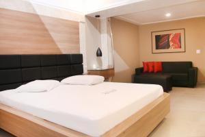 a bedroom with a large bed and a couch at Motel Hollywood in Salvador +19 photos