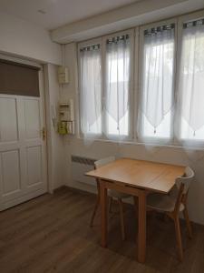 una mesa y sillas en una habitación con ventanas en Petit studio à BORDEAUX CHARTRONS / JARDIN PUBLIC (6), en Burdeos