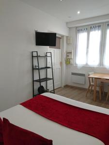 1 dormitorio con cama, mesa y TV en Petit studio à BORDEAUX CHARTRONS / JARDIN PUBLIC (6), en Burdeos