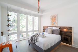 a bedroom with a bed and a large window at Elegant Downtown Home in Toronto