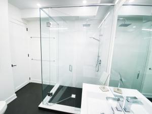 a bathroom with a glass shower and a sink at Elegant Downtown Home in Toronto