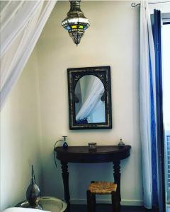a mirror on a wall with a table and a stool at Ajamola in Favignana