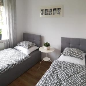 ein Schlafzimmer mit 2 Betten und einem Tisch mit einem Tisch in der Unterkunft Apartament Bursztynowy Jantar 2 pokojowy in Jantar