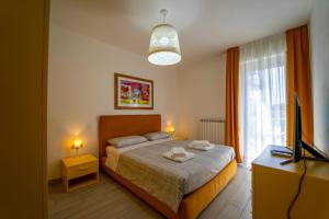 a bedroom with a bed and a tv and a window at La Luna nel Golfo - Appartamenti a Follonica in Follonica