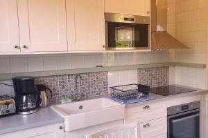 a kitchen with a sink and a microwave at Lilla Kari in Varberg