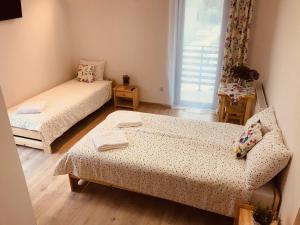 Habitación pequeña con 2 camas y ventana en Pokoje Gościnne Lena, en Święta Katarzyna