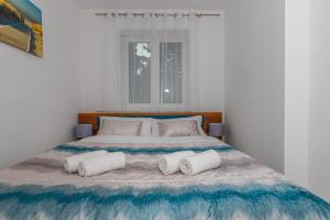 una camera bianca con un grande letto con due cuscini di Apartmani Kecman a Crikvenica